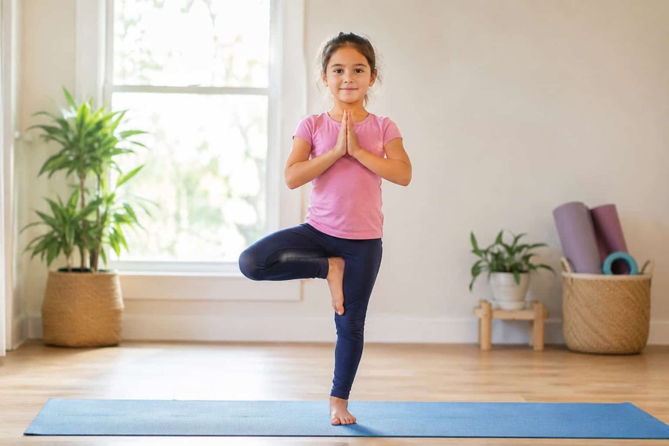 Mädchen macht Baum-Pose beim Kinderyoga – einfache Übung für Kinder nach der Schule Mädchen macht Baum-Pose beim Kinderyoga – einfache Übung für Kinder nach der Schule